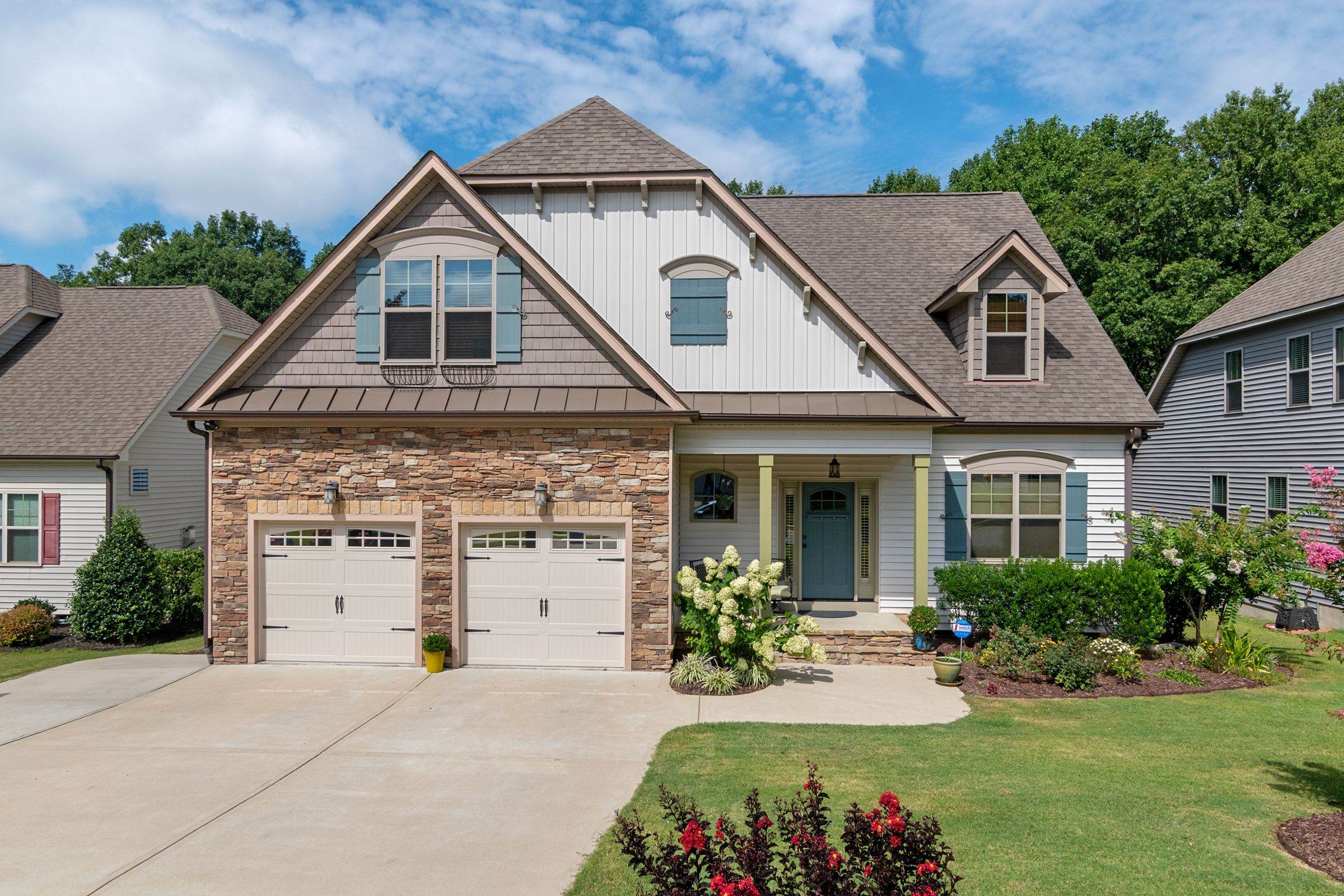 Brick and painted-siding home with a two-car garage and neat front landscaping